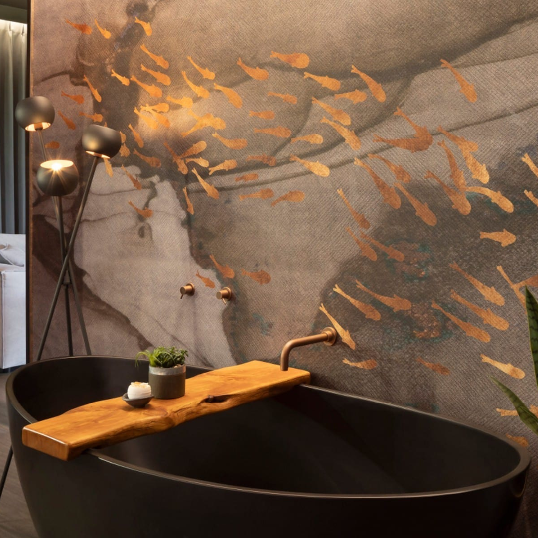 A white bath bomb sitting on a wooden tray in a bathtub with a plant next to it.