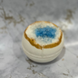 Geode bath bomb with a blue center on a marble surface