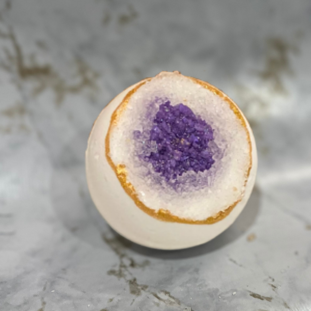 Bath bomb with a purple center on a marble surface