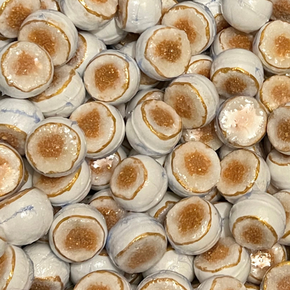 Close-up of white and gold and white geode-pattern bath bombs.